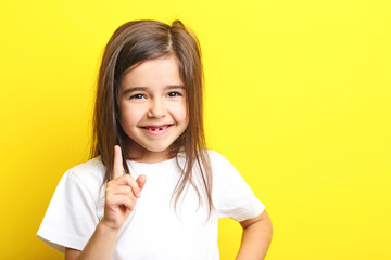 Beautiful little girl on yellow background