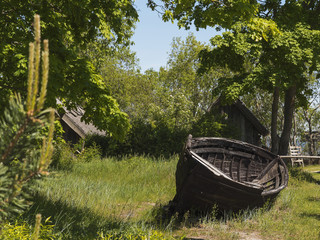 Old grungy wooden fishing boat and old style houses in the background.