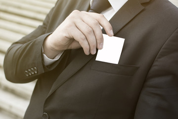 Close-up of a businessman's hand holding a business card. Blank business card. Copy space on a business card.