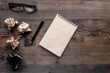 Writer concept. Feather pen, vintage notebook and crumpled paper on wooden table background top view copyspace mockup