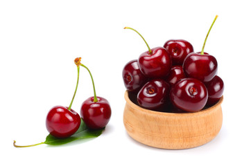 cherries in wooden bowl isolated on white background.