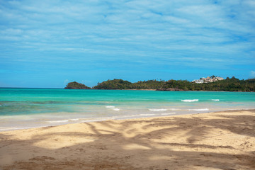 Caribbean beach. Azure caribbean sea and sandy beach on background of green islands