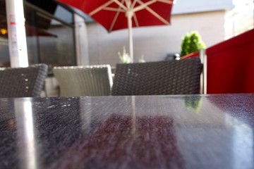 Blurry image of café tables, chairs and red canopy