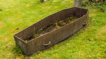 Iron coffin open in a country churchyard