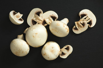 Top view white mushrooms on black slate plate