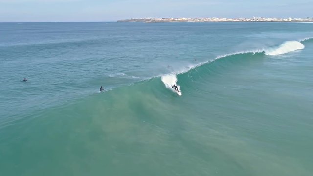 Aerial footage of a surfer surfing a perfect wave in Portugal. 4k quality in slowmotion.