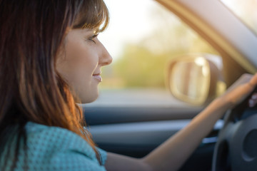 Fototapeta na wymiar beautiful brunette drives a car. woman driving: risk or myth.