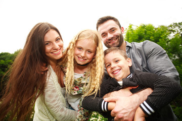 Closeup portrait of happy smiling family in city park