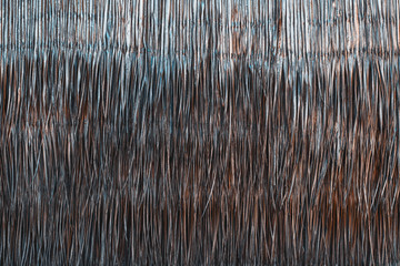 Texture of sticks within a brush fence, landscaping fencing – close-up detail, part of the wall of bungalow in Maldives made of dry palm leaves and branches