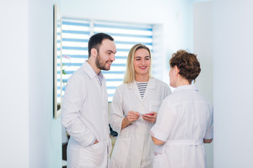 Obraz premium Mature doctor discussing with nurses in a hallway hospital. Doctor discussing patient case status with his medical staff after operation.