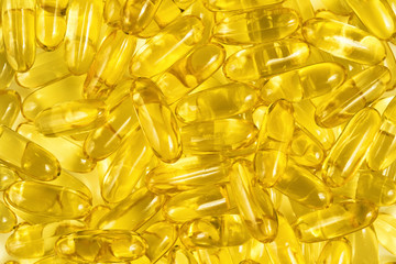 Fish oil gel capsules of omega 3. Close up capsules fish oil in wooden spoon. The supplement high vitamin E omega 3 and DHA. Background