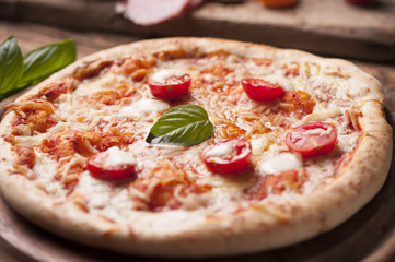 rustic italian pizza with mozzarella, cheese and basil leaves