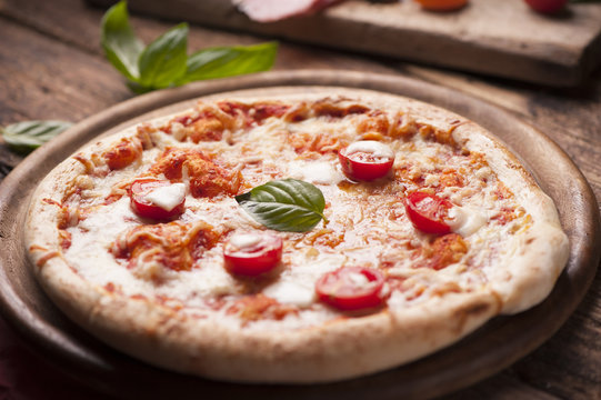 rustic italian pizza with mozzarella, cheese and basil leaves