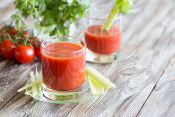 Tomato juice in a glass with celery and tomatoes