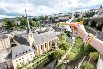 Holding a toy airplane on the old town background in Luxembourg city