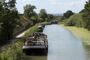 An old sailing barge alongside the Kennet & Avon Canal looking west from Marsh Lane Bridge Devizes, Wiltshire England UK