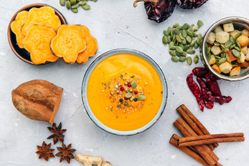 Bowl with fresh homemade sweet potato pumpkin soup and spices.