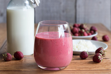 Homemade kefir with strawberries on a wooden background