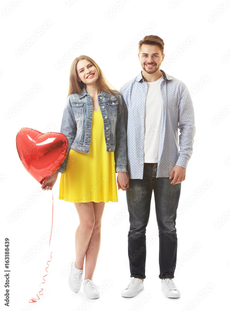 Wall mural Cute young couple with balloon in shape of heart on white background