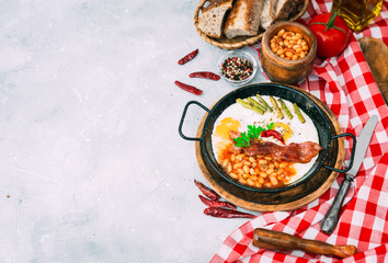english breakfast with eggs, tomatoes, mushrooms, bacon, beans, and sausage