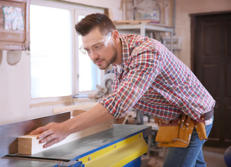 Carpenter preparing timber on table saw