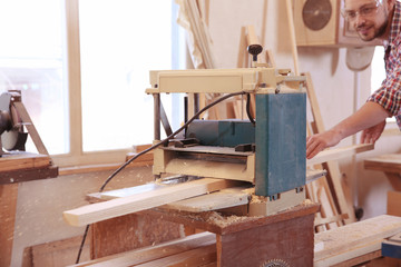 Carpenter working with grinder in shop