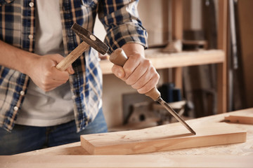 Carpenter working with chisel in shop