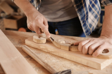 Carpenter working with chisel in shop