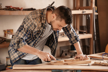 Carpenter working with chisel in shop