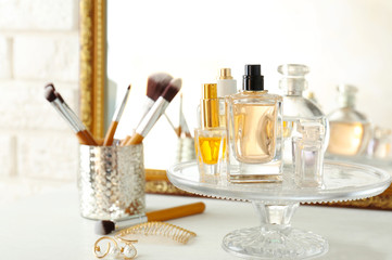 Obraz na płótnie Canvas Glass stand with perfume bottles on white table