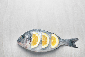 Fresh dorado fish with lemon slices on light background
