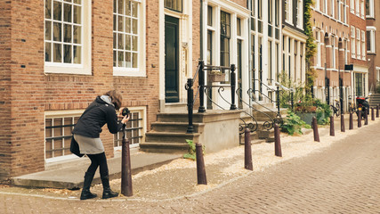 Fototapeta na wymiar AMSTERDAM, HOLLAND - May 10 2017: woman photographer on the street.