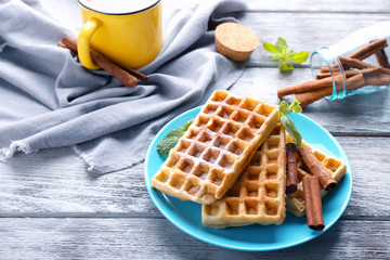 Delicious cinnamon waffles with mint leaves on table