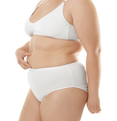 Overweight young woman in underwear on white background. Diet concept