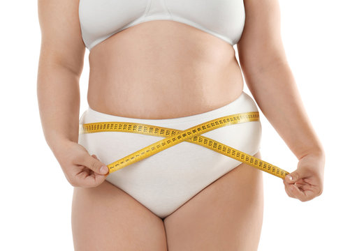 Overweight woman in underwear measuring her waist on white background. Diet concept