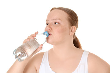 Overweight young woman drinking water on white background. Diet concept