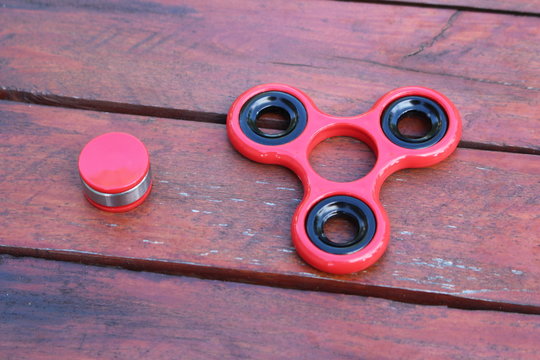 two red fidget spinner parts on wooden table