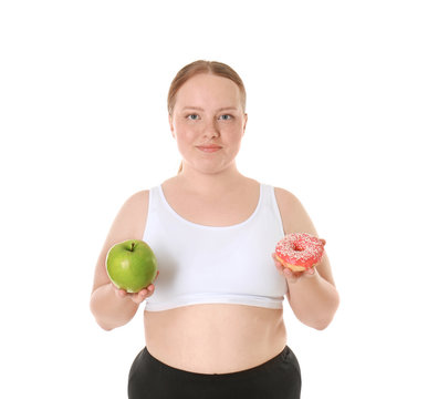 Overweight young woman with apple and donut on white background. Diet concept