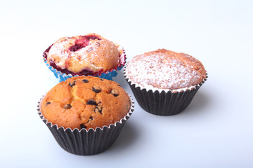Homemade Blueberry and chocolate muffins with powdered sugar and fresh berries.