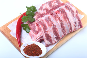 Raw pork ribs with herbs and spices on wooden board. Ready for cooking.