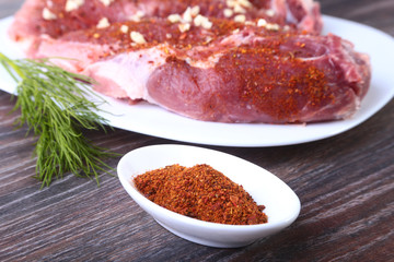 Spices for pork steaks on wooden board with herbs, garlic. ready for cooking. Selective focus