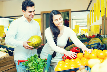 Fototapeta premium couple buying fresh seasonal fruits in market