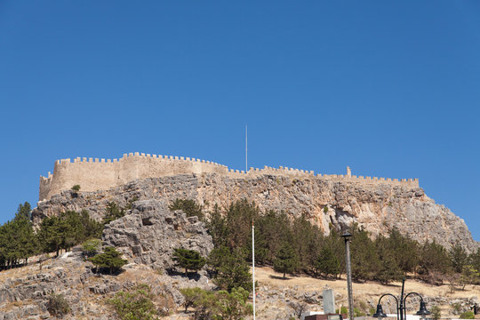 Rock with antique temple acropolis. Acropolis hill in the town of Lindos from the bay side.