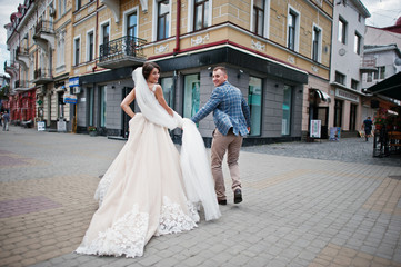 Obraz premium Flawless wedding young couple walking on city streets on a sunny day.