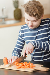 Close up on child carefully cutting carrots