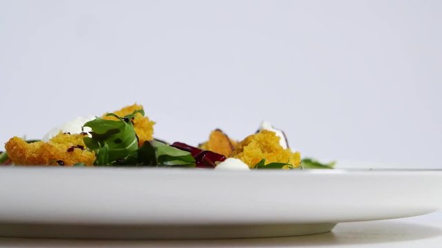 Italian Roast Beet Salad. Salad of roasted beets with goat cheese and pine nuts on white dish isolated on a white background. Tagliatelle with beet and cheese on plate, soft focus