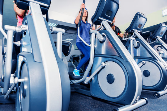 Bottom view on group of people diligently exercising on the crosstrainer machines