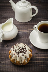 cake in glaze, cup of coffee, creamer and teapot/cake in glaze, cup of coffee, creamer and teapot. Top view