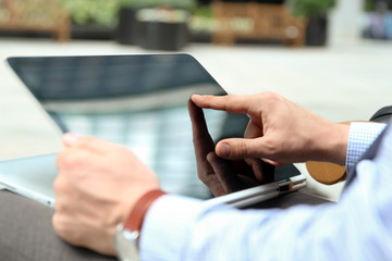 Business man working and analyzing financial figures on a graphs on a laptop outside