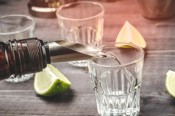 Pouring alcohol into a shot on bar background/     Pouring alcohol into a shot on bar background. Toned